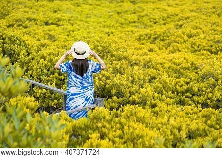 Asian Traveler Woman Holding The Hat And Standing On Wooden Bridge For Travel At Tung Prong Thong Fo