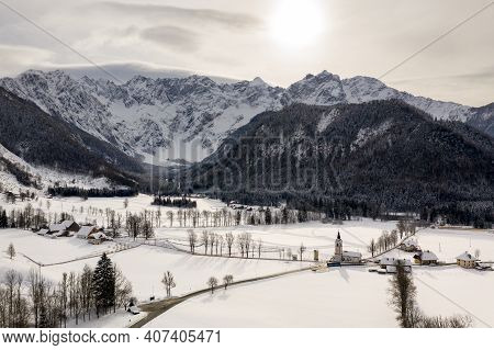 Aerial Winter Landscape With Mountain Village And Forest Covered In Snow. Zgornje Jezersko, Slovenia