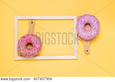 Donuts With Pink Icing On A Yellow Background. Flat Lay. Copyspace Buying Sweets