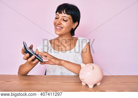Beautiful brunettte woman caculating money savings smiling with a happy and cool smile on face. showing teeth. 