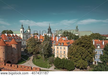 Warsaw, Poland Summer View Of Barbican Or Barbakan Wall And Old Town Houses With Green Trees And Blu