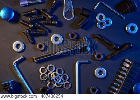 Different Screws, Nuts, Washers, Screwdrivers On Black Background. Hardware Tools And Metal Bolts, N