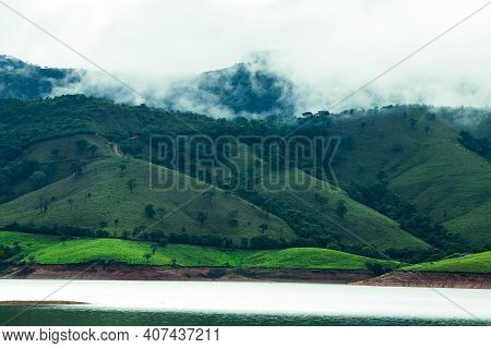 Mountains Next To A Lake With Clouds Evaporating At The Hilltop After A Rainfall During The Afternoo