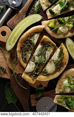 Cutted Green Pizzas On Oak Wood Cutboards With Green Vegetables Close Up