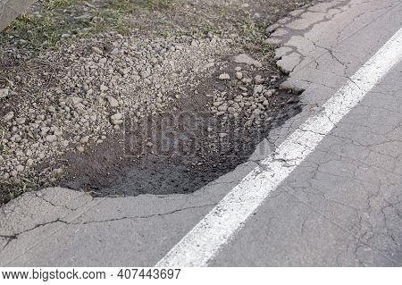 Pothole With Cracks Tarmak Road With White Markings Solid Line, Pit On The Side Of The Road Danger O