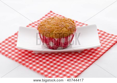 En Cupcake på en rød mønstrede serviet og plade