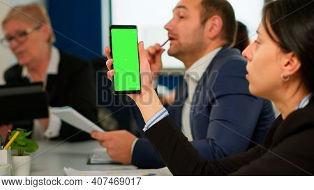 Businesspeople Analysing Annual Financial Reports Sitting At Desk While Employee Holding Phone With 