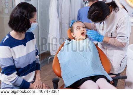 Little Girl In The Course Of Dental Treatment From Young Dentist In Office. Dentistry Specialist Dur