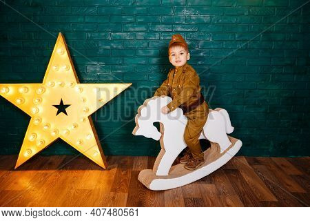 Child In A Suit. Kid Riding White Horse. The Boy Is Preparing To Learn Pony Riding. Portrait Of Litt