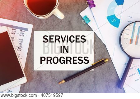 Services In Progress Is Written In A Document On The Office Desk With Office Accessories, Coffee, Di