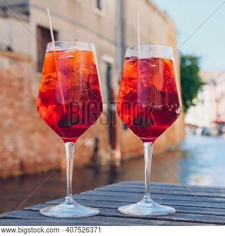 Two glasses of Spritz Veneziano cocktail served near the Venetian canal.  Popular italian summer ape