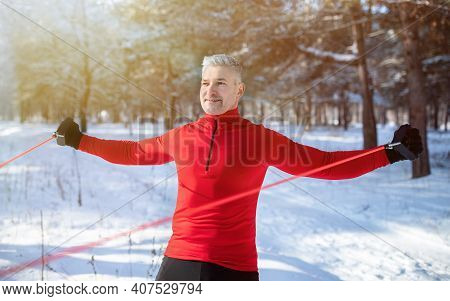 Functional Workout. Fit Mature Man Exercising With Bodyweight Resistance Straps At Forest On Cold Sn