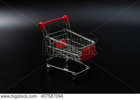 Small Red Shopping Cart On A Black Background. Copspace