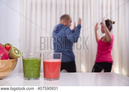 Green Smoothie With Focused Kiwis And Woman Exercising On Unfocused Background