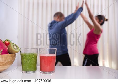Green Smoothie With Focused Kiwis And Woman Exercising On Unfocused Background