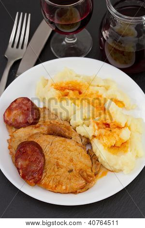 Carne con Chourico e purè di patate e bicchiere di vino rosso