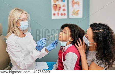 African American Female Kid Having Pcr Test During Coronavirus Epidemic. Doctor Wearing A Protective