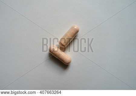 Top View Of Two Pink Capsules Of Probiotic Dietary Supplement