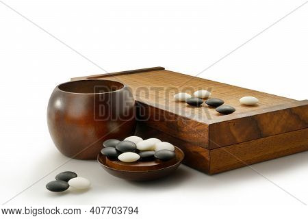 Black And White Stones Of Baduk Game On Wooden Board Isolated On White