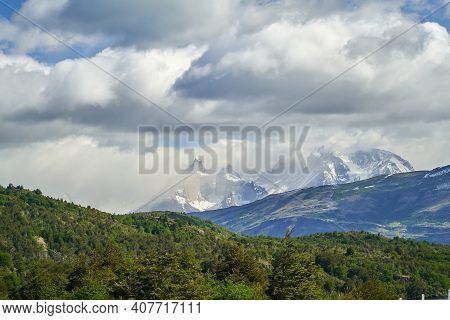 Horns Of Torres Del Paine Towering Over A Mountain Ridge With Dark Green Forest At Torres Del Paine 