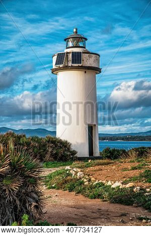 A Beautiful Solar Powered Lighthouse With A Spectacular Cloudy Sky In The Background. Porto Conte Li