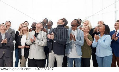 Business leaders with team of employees looking up. Happy profes