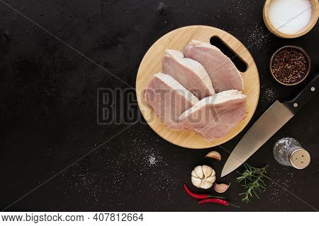Cut Raw Beef With Spices In Plate And Rosemary. On Dark Rustic Background. Top View With Copy Space.