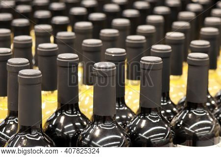 Wine Bottles In A Row, Selective Focus. Liquor Store, Red And White Wine Production Concept