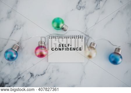 Positive Attitude Concept, Self--confidence Text On Notepad Surrounded By Light Bulbs