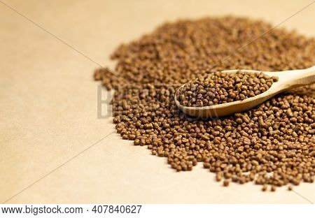 Buckwheat Tea In A Wooden Spoon On A Brown Background. Buckwheat Tea Close-up Macro Photography. Sca