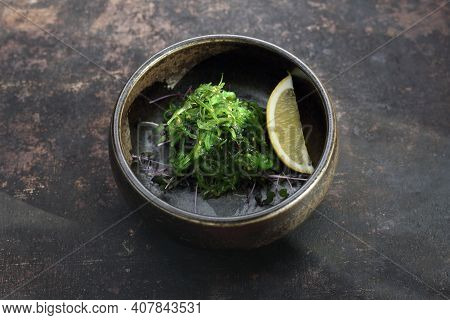 A Pickled Seaweed Japanese Salad. A Goma Wakame, Top View, On A Black Stony Background.