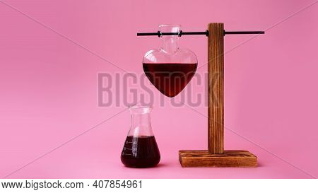 Valentines Day Potion. Love Potion In The Shape Of A Heart On A Pink Background. Chemical Flask.