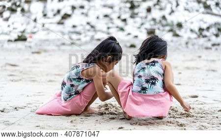 Two Little Kids Making Sand Castle And Playing At Tropical Beach. Little Girls Back View While Playi