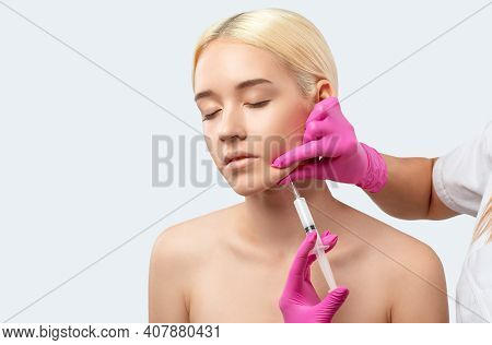 Cosmetologist Makes Lipolytic Injections To Burn Fat On The Chin, Cheeks And Neck Of A Woman Against