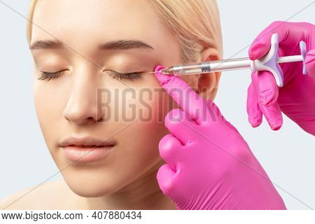 Cosmetologist Makes Rejuvenating Anti Wrinkle Injections On The Face Of A Beautiful Woman. Female Ae