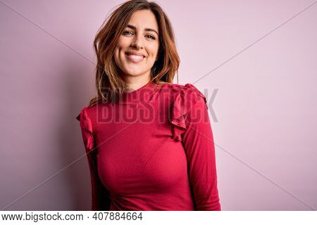 Young beautiful brunette woman wearing casual sweater stnding over pink background with a happy and cool smile on face. Lucky person.