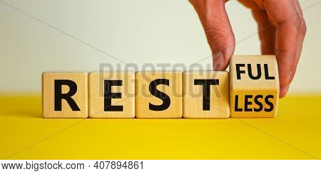 Restless Or Restful Symbol. Businessman Turns The Wooden Cube, Changes The Word 'restless' To 'restf