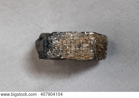 A Sample Of A Mineral Found In The Arctic On Dixon Island, Tourmaline, On A Gray Background, Close-u