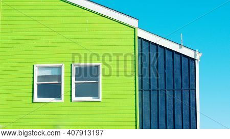 Bright Gren Building Detail On Blue Background With Two Symmetric Wondows.