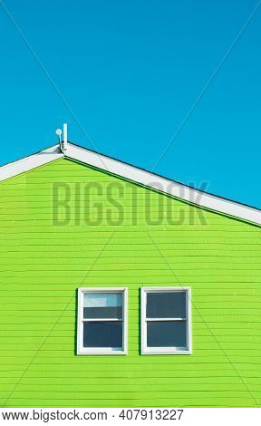 Bright Gren Building Detail On Blue Background With Two Symmetric Wondows.