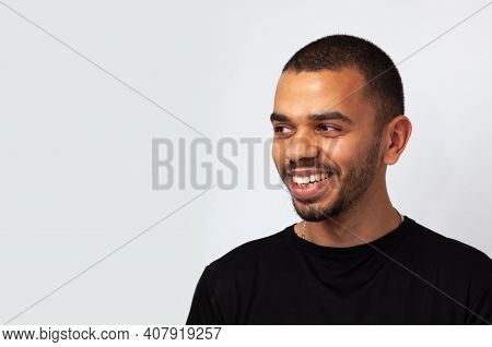 Young Attractive Blackskin Man Smiling Looking Aside In Black Sweathshot Isolated, Side Copy Space