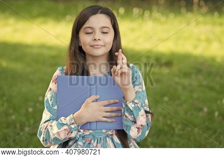 Making A Wish. Little Child Cross Fingers For Luck. Small Girl Hold Book In Park. Follow Your Dream.