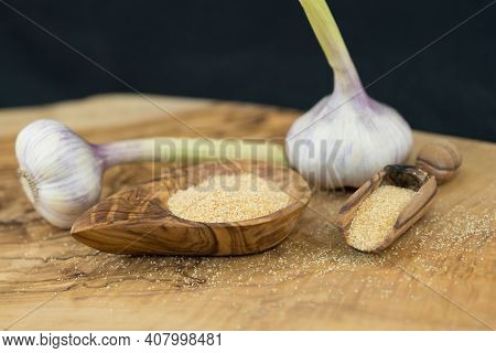Dried Garlic Granules On Brown Olive Wood