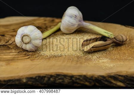 Dried Garlic Granules On Brown Olive Wood