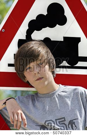 Portrait Of A Cool Boy In Front Of An Locomotive Traffic Sign
