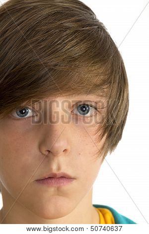 Closeup Of A Cute Teenage Boy Looking Into The Camera, Isolated On White