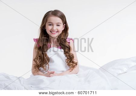 Happy Little Girl Awake And Sitting In The Bed.