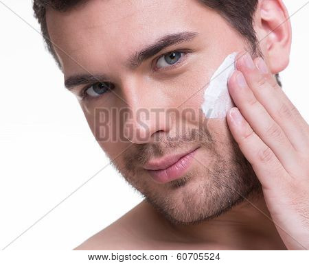 Young Handsome Man Applying Cream.