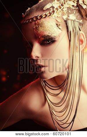 Art project: beautiful woman with golden make-up. Jewelry, make-up. Fashion.
