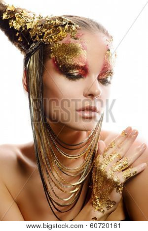 Art project: beautiful woman with golden make-up. Jewelry, make-up. Fashion. Isolated over white.